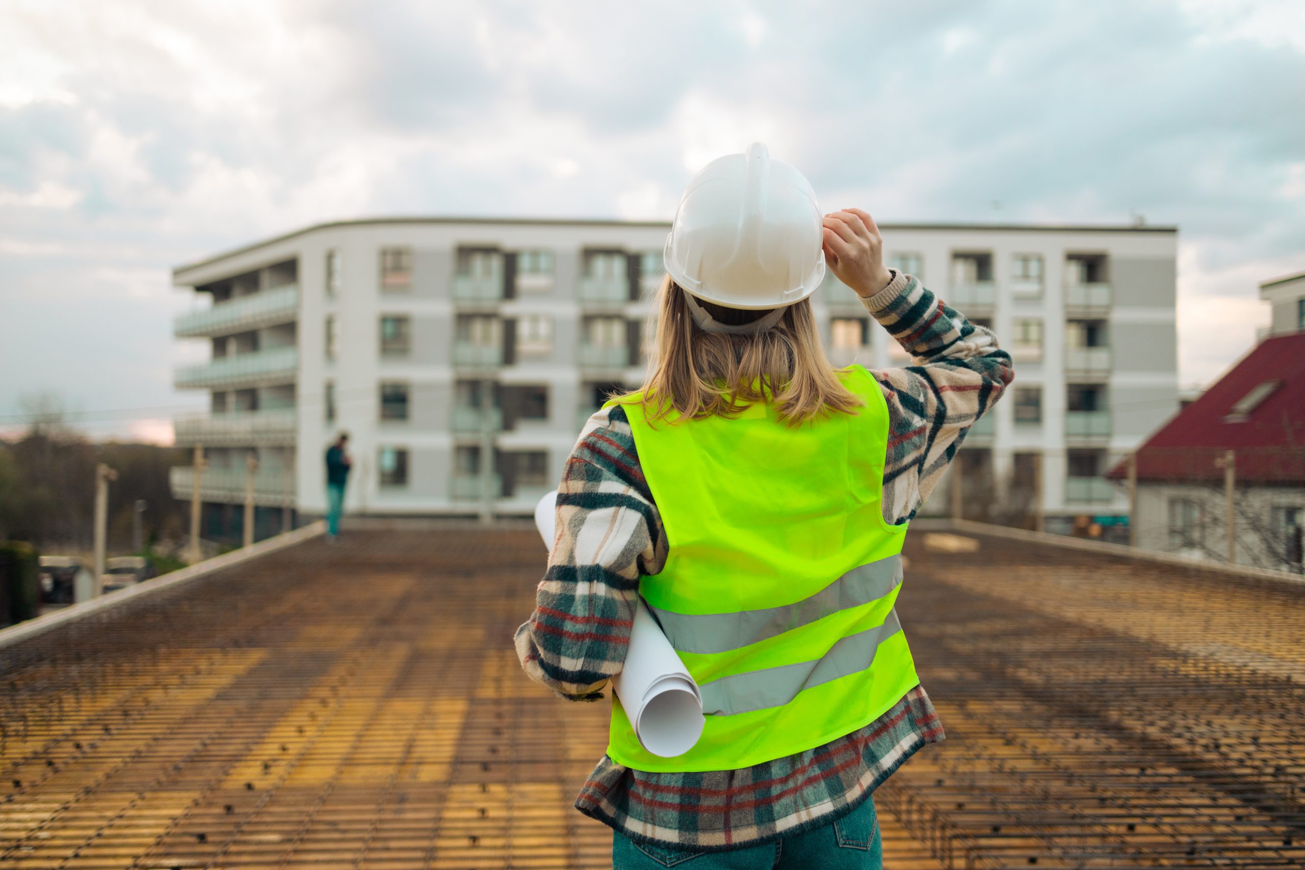 female construction worker under inspection and checking standing on construction site, working.